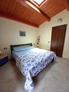 1 dormitorio con 1 cama con colcha azul y blanca en Casuzza Serena, en Granelli