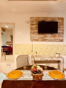a table with two plates and a television on a wall at Hotel Villa de Carli in Bagé