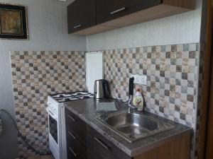 a kitchen with a sink and a stove at Sunrise in Rēzekne +3 photos
