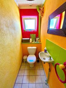 a colorful bathroom with a toilet and a sink at Chambres d'Hôtes Lefoulon in Pirou