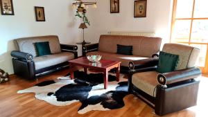 Sala de estar con 2 sofás y mesa en Ferienwohnung Landhausliebe en Zwiesel