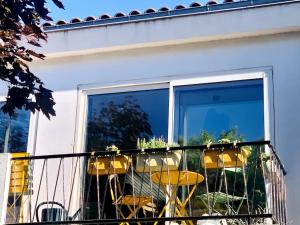 d'un balcon avec une table, des chaises et une fenêtre. dans l'établissement L'Étoile Des Sables - Maison de ville climatisée classée 4 étoiles - 4 personnes - Plage de la Grande Conche à 200m - ROYAN, à Royan