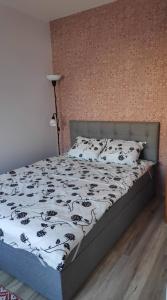 a bedroom with a bed with a black and white comforter at Maria Apartment Roomassaare in Kuressaare