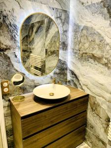 a bathroom with a sink and a mirror at L'Étoile Des Sables - Maison de ville climatisée classée 4 étoiles - 4 personnes - Plage de la Grande Conche à 200m - ROYAN in Royan