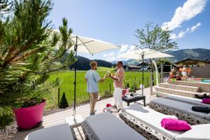 Twee mannen staan onder een paraplu op een patio. bij Enjoy The Alps in Flachau