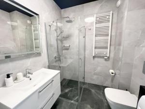 uma casa de banho com um chuveiro, um lavatório e um WC. em Dream4You Apartments em Breslávia