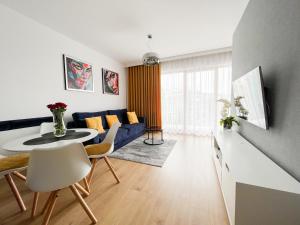 uma sala de estar com um sofá azul e uma mesa em Dream4You Apartments em Breslávia