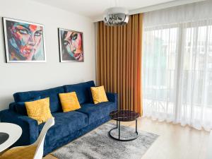 sala de estar con sofá azul y mesa en Dream4You Apartments, en Wroclaw