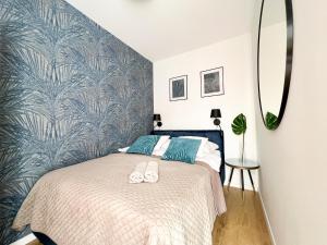 sypialnia z łóżkiem z niebieską wzorzystą ścianą w obiekcie Dream4You Apartments we Wrocławiu