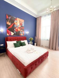 una camera con un grande letto su una parete blu di Royal 2 apart in center a Lviv