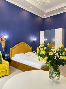 una camera da letto con un letto e un vaso di fiori su un tavolo di Royal 2 apart in center a Lviv