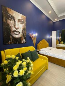 un soggiorno con divano giallo e un dipinto di Royal 2 apart in center a Lviv