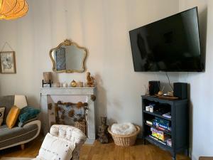 a living room with a flat screen tv on the wall at La Terrasse de Compostelle T3 Chic, Charme, Cosy in Saint-Léonard-de-Noblat