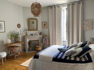 a bedroom with a bed with pillows and a fireplace at La Terrasse de Compostelle T3 Chic, Charme, Cosy in Saint-Léonard-de-Noblat