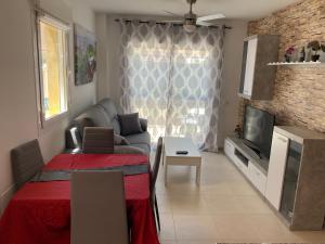 Una sala de estar con un sofá y un televisor. en Ruben House, en Vera