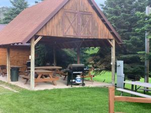 a wooden pavilion with picnic tables and a grill at Chalet in Hill City +5 photos