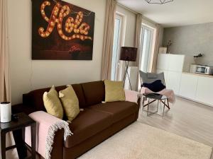 sala de estar con sofá marrón y mesa en Jezerní apartmán s terasou a saunou v Lakepark Residence, en Doksy