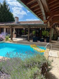 an outdoor patio with a swimming pool and a pergola at La Chantourelle in Landricourt
