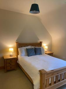 um quarto com uma cama grande e 2 mesas de cabeceira em Racecourse Lodge Apartment em Clifden