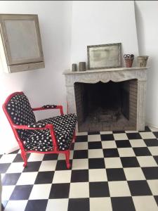 uma sala de estar com uma cadeira e uma lareira em Casa Divota au cœur d’un village paisible em Santa-Reparata-di-Balagna