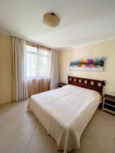 ソゾポルにあるPrivate 2 Rooms Apartment in Santa Marina Villageの大きなベッド付きのベッドルーム1室、壁に絵画が飾られています。