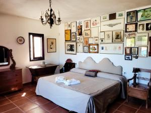 1 dormitorio con 1 cama y una pared de cuadros en LOS MORALICOS AGUA AMARGA, en Agua Amarga