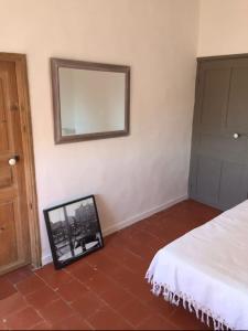 a bedroom with a mirror on the wall and a bed at Casa Divota au cœur d’un village paisible in Santa-Reparata-di-Balagna