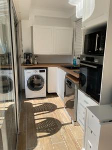a kitchen with a washing machine and a washer at appart spa et mer in Bormes-les-Mimosas +7 photos