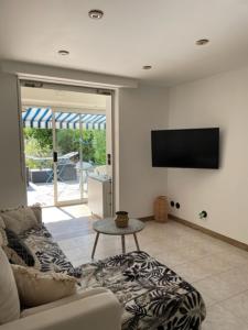 ein Wohnzimmer mit einem Sofa und einem Flachbild-TV in der Unterkunft appart spa et mer in Bormes-les-Mimosas