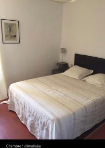 um quarto com uma cama grande e um cobertor branco em Casa Divota au cœur d’un village paisible em Santa-Reparata-di-Balagna