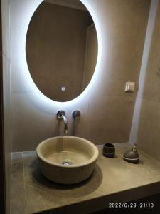 een badkamer met een wastafel met een ronde spiegel bij Christina Kos Boutique Apartments in Kos-stad