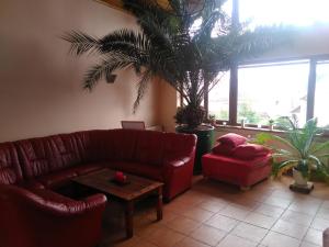 Pod palmou Gerlachov في غيرلاتشوف: غرفة معيشة مع أريكة حمراء وطاولة