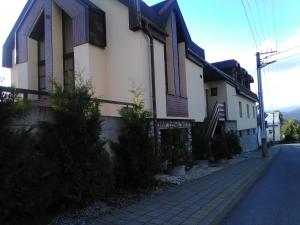 a house on a street next to a sidewalk at Pod palmou Gerlachov in Gerlachov