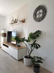 a living room with a clock and a potted plant at Noa in Orebić