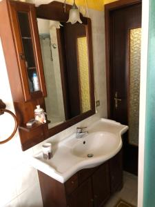a bathroom with a white sink and a mirror at La casa di Marco in Imperia