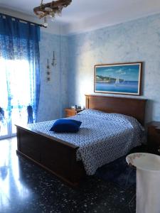a bedroom with a bed with a blue bedspread at La casa di Marco in Imperia