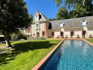 a house with a swimming pool in front of a yard at Château de Beauvais in Azay-sur-Cher