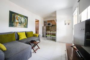 sala de estar con sofá gris y almohadas amarillas en Apartment Apple Dunes with Pool Corralejo By Holidays Home, en Corralejo