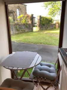 a view of a table and chairs outside a window at Sandy's Barn, Foolow, Dogs Welcome in Foolow