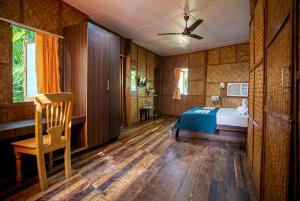 una camera con un letto e una sedia di Palm Grove Eco Resort a Port Blair