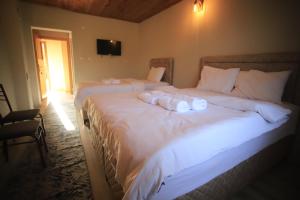 a bedroom with two beds with white sheets and a television at Kanyon park otel ve restaurant in Demirci