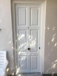 een witte deur in een witte kamer met bij Residence Santa Maria Suites in Marina di Camerota