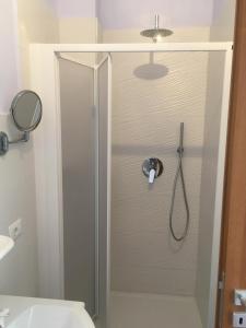 een douche met een glazen deur in de badkamer bij Residence Santa Maria Suites in Marina di Camerota