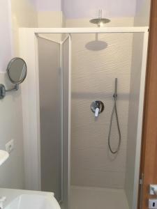 una doccia con porta in vetro in bagno di Residence Santa Maria Suites a Marina di Camerota