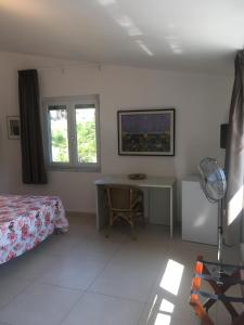een slaapkamer met een bureau, een bed en een tafel bij Residence Santa Maria Suites in Marina di Camerota