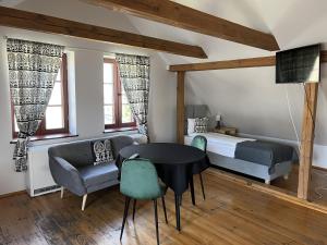 a bedroom with a bed and a table and chairs at Gościniec FOLKier in Zgierz