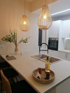 een keuken met een aanrecht met een wastafel en twee verlichting bij Christina Kos Boutique Apartments in Kos-stad