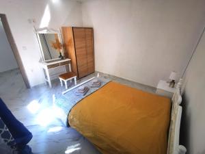 ein Schlafzimmer mit einem gelben Bett und einem Spiegel in der Unterkunft Stegna Blue Shell in Archangelos