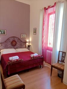 1 dormitorio con cama roja y ventana en La Petite Maison en Florencia