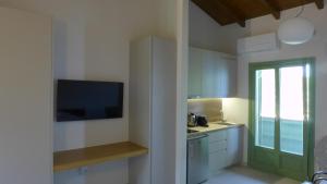 eine Küche mit einem TV und eine Küche mit einer Spüle in der Unterkunft Caltabania Suites in Agios Nikitas